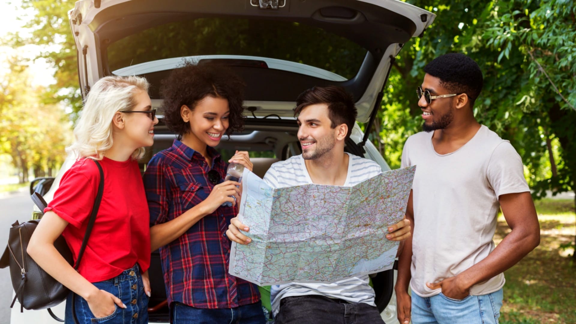 Group of friends viewing a road map.