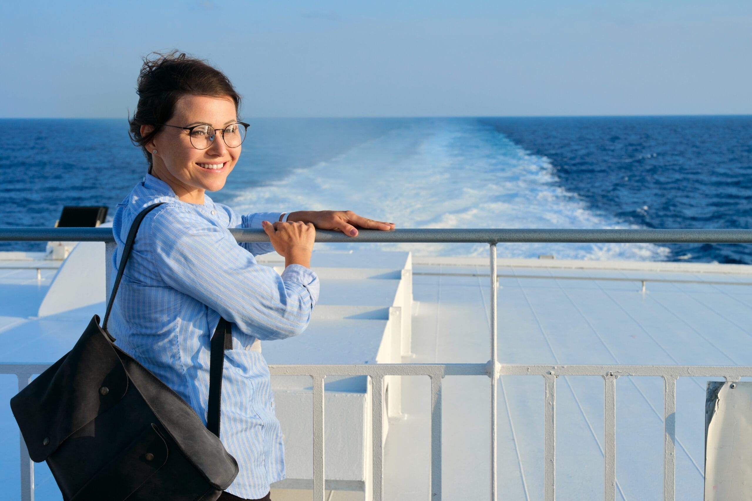 Happy woman on deck of cruise ship at sea