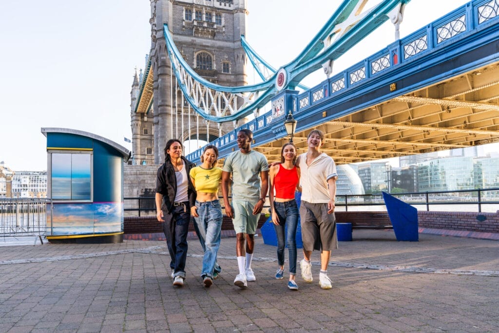Group of young friends walking in London near the Tower Bridge.