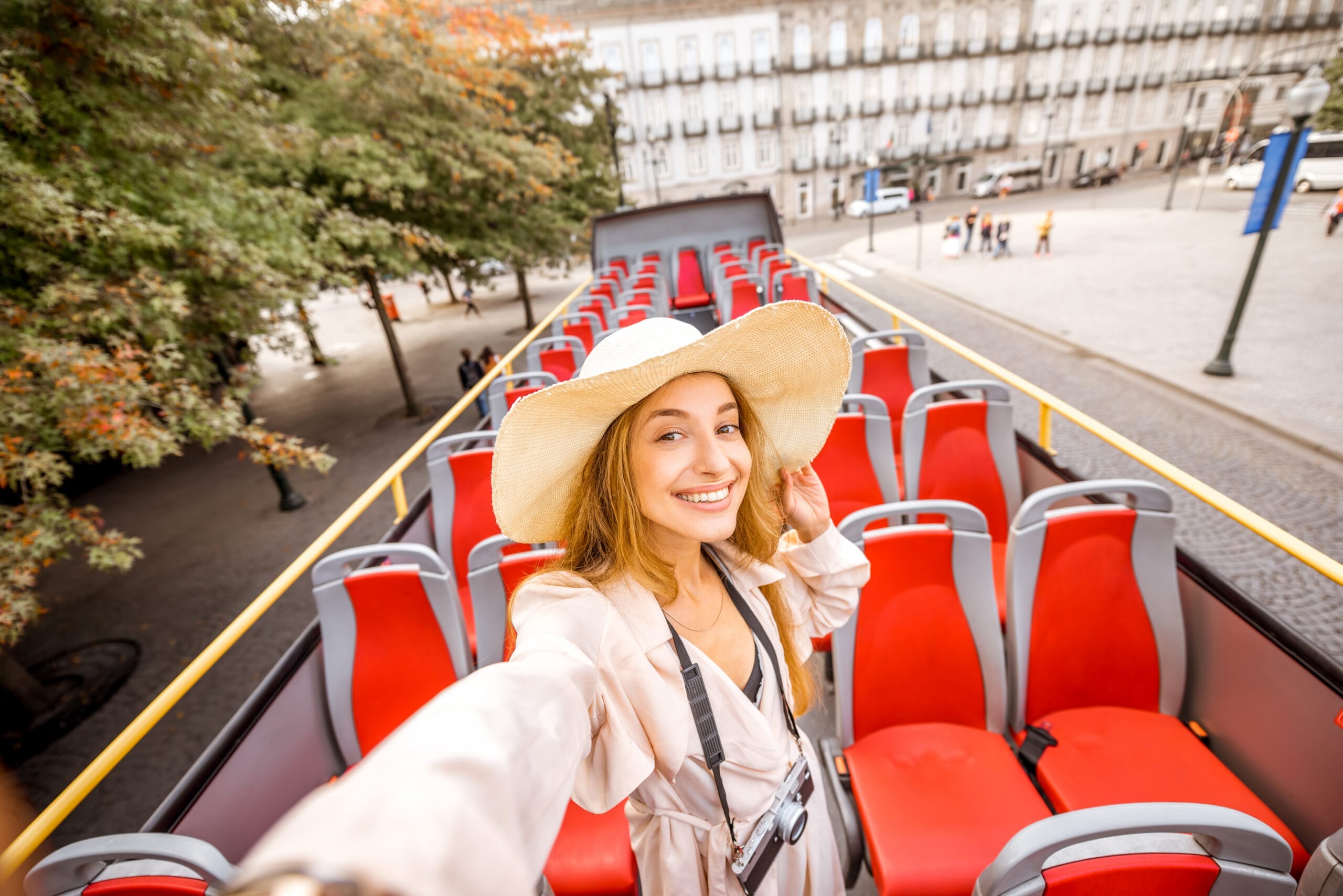 Happy woman having excursion on the open-top bus.
