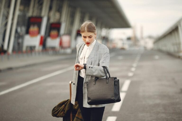 Woman wondering how early should you arrive at the airport on her watch.